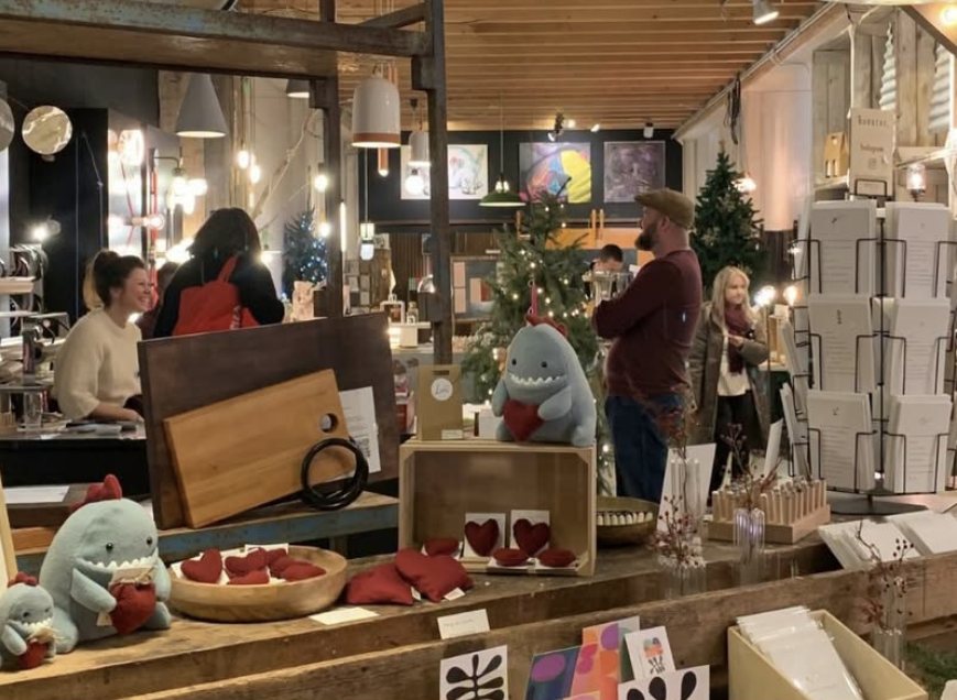 Bezoekers tussen handgemaakte producten, kaarten en kerstbomen in de winkel van INTTER tijdens wINTTERvrienden